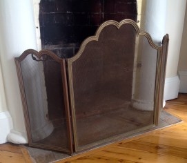 A small brass spark screen for the fireplace under restoration.